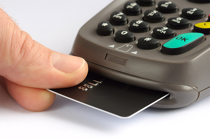 person taking their credit card out of a scanner
